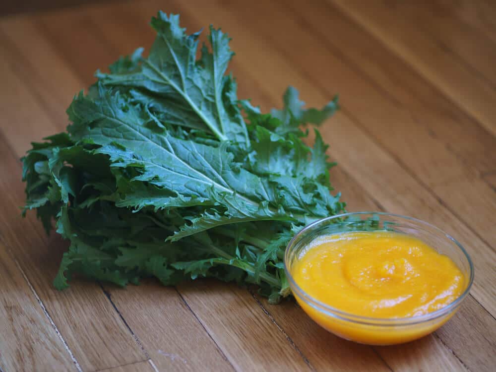 Mustard greens and pumpkin puree on table