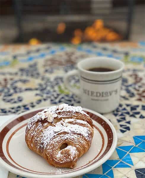 Niedlov's croissant with a cup of coffee